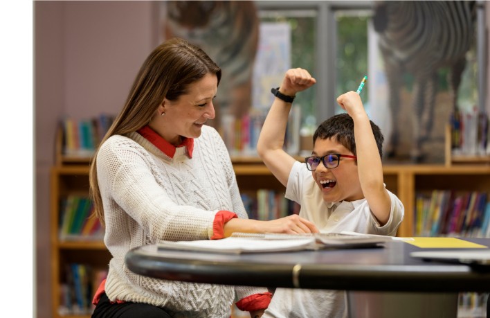 A Skill Studio clinician celebrating a breakthrough moment with a young student